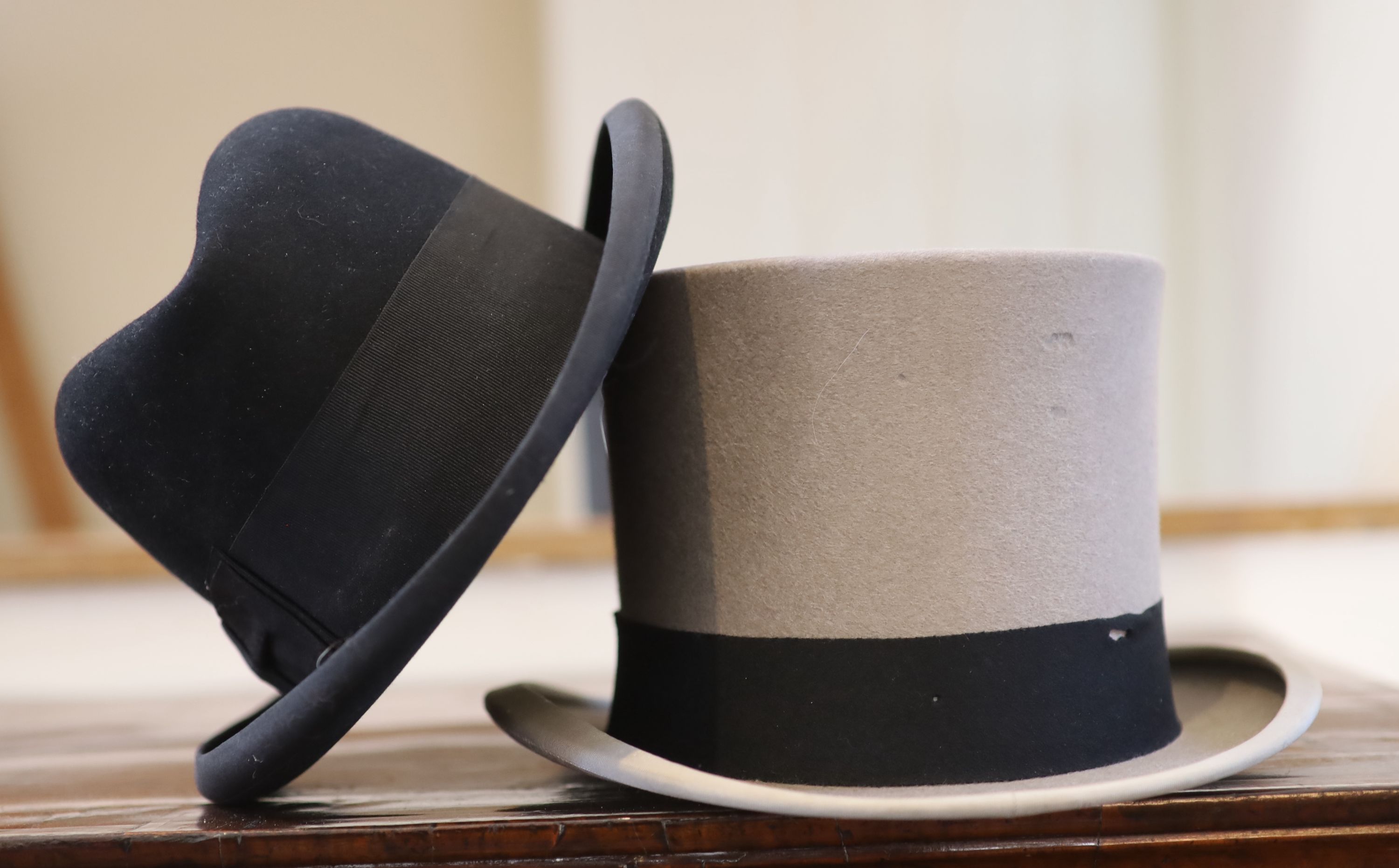 A grey top hat, a black Trilby hat and a bottle green and black uniform